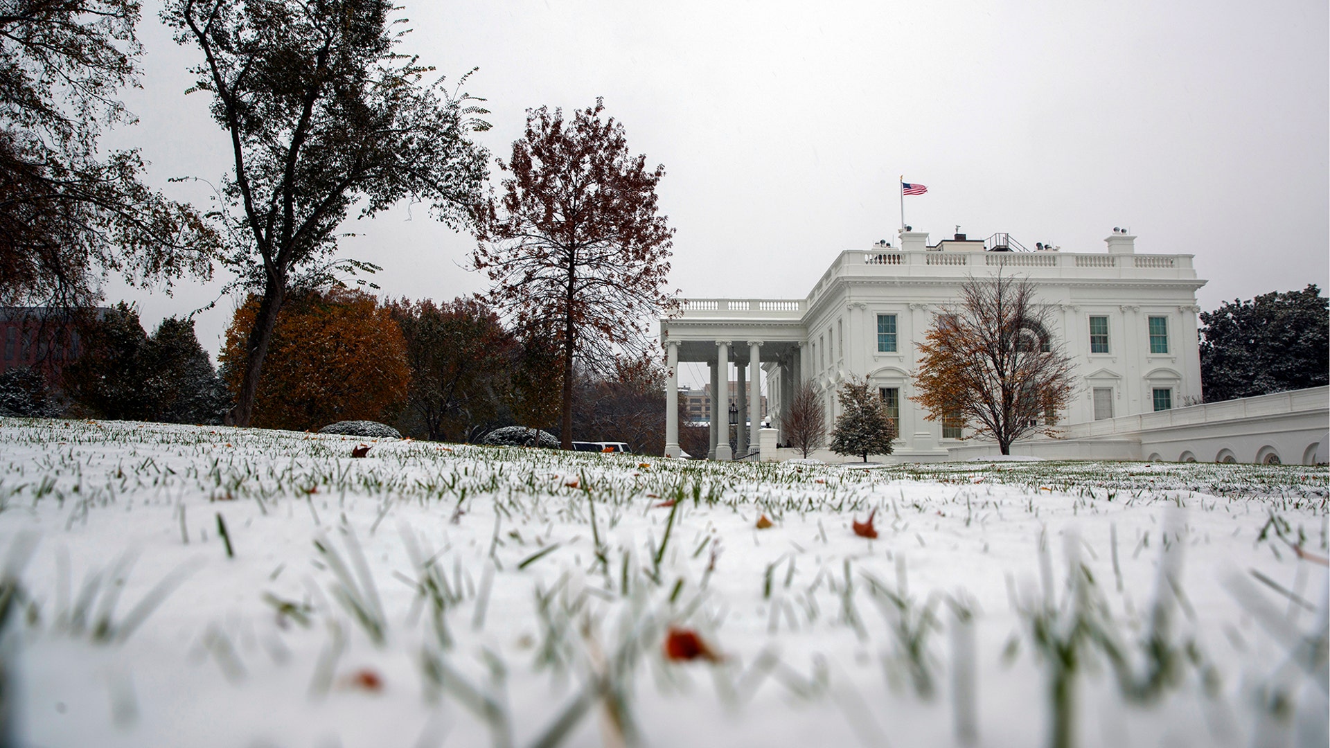 Snow covers the grass outside of the White House in Washington, November 15, 2018.
