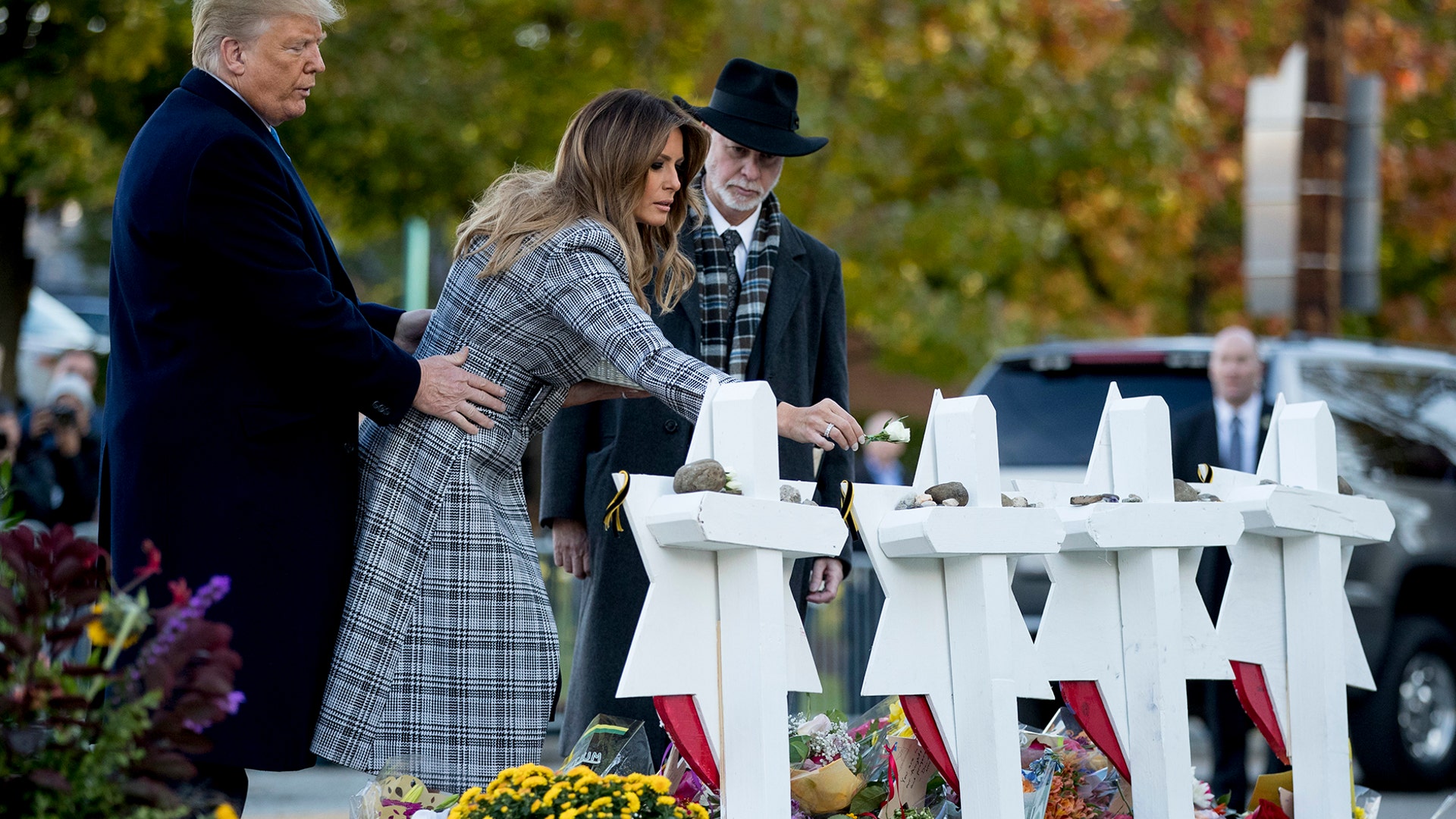 First lady Melania Trump, accompanied by President Trump and Rabbi Jeffrey Myers, puts down a white flower at a memorial for those killed at the Tree of Life Synagogue in Pittsburgh, Oct. 30, 2018. 