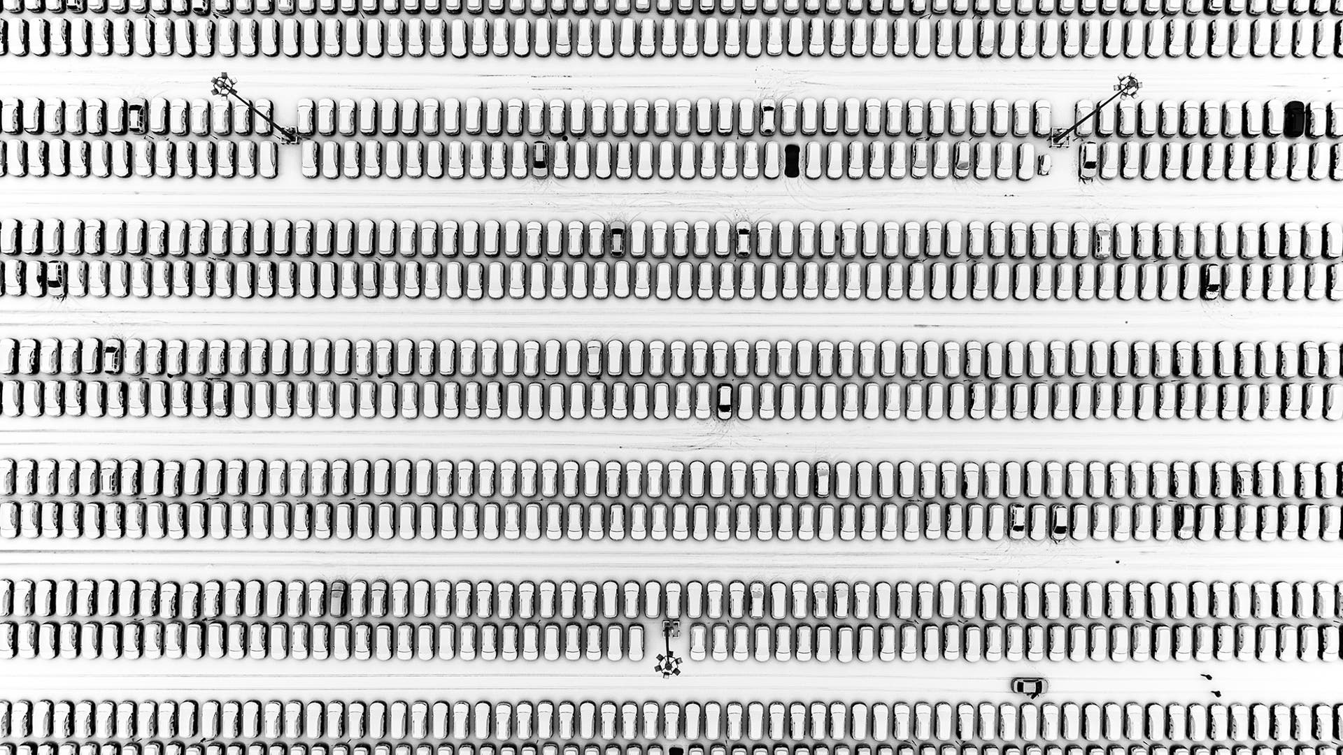 Rows of parked cars located in a shopping center parking lot are covered by the first snowfall in Moscow, Russia, Nov. 28, 2018. 