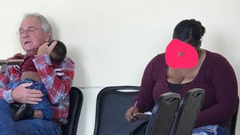 Heartwarming moment man holds sleeping baby so mom can fill out paperwork goes viral