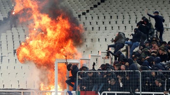 European soccer fans left bloodied after violent rivals throw petrol bombs and flares into the stands