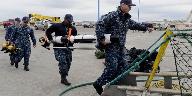 U.S. Navy personnel load equipment onto the Skandi Patagonia ship in Comodoro Rivadavia, Argentina, Tuesday, Nov. 21, 2017. Experts worry that if the ARA San Juan submarine is intact but submerged, its crew might have only enough oxygen to last seven to 10 days.