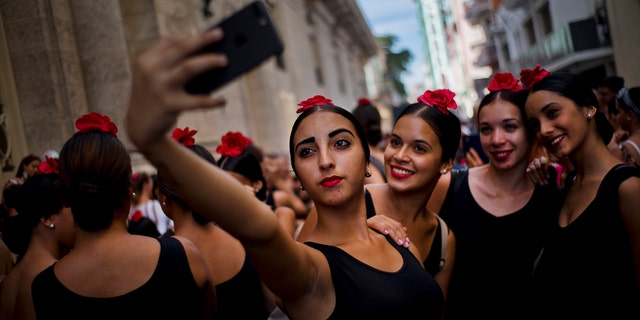 Young flamenco dancers take a selfie before performing in the street during the 26th International Ballet Festival in Havana, Cuba, Sunday, Nov. 4, 2018. (Associated Press)
