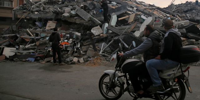 Palestinians survey a destroyed residential building hit by Israeli airstrikes, in Gaza City, Tuesday, Nov. 13, 2018. (AP Photo/Hatem Moussa)