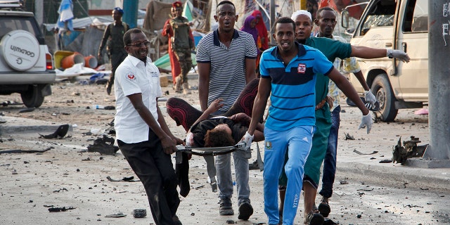 Somalis carry away an injured civilian who was wounded in a bomb blast near the Sahafi hotel in the capital Mogadishu, Somalia.