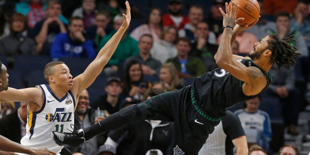 Minnesota Timberwolves' Derrick Rose, right, takes a fall-back shot as Utah Jazz's Dante Exum defends in the first half of an NBA basketball game Wednesday, Oct. 31, 2018, in Minneapolis.