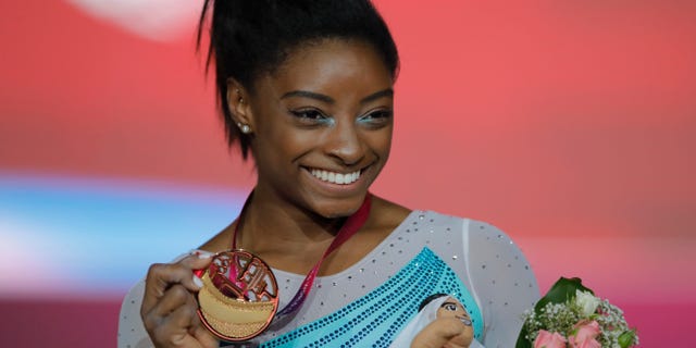 Gold medallist and four-times All-Around world champion Simone Biles of the U.S., poses on the podium after the Women's All-Around Final of the Gymnastics World Championships at the Aspire Dome in Doha, Qatar, Thursday, Nov. 1, 2018. (AP Photo/Vadim Ghirda)