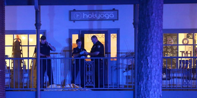 Police investigators work the scene of a shooting, Friday, Nov. 2, 2018, in Tallahassee, Fla. A shooter killed one person and critically wounded four others at a yoga studio in Florida's capital before killing himself Friday, officials said. (AP Photo/Steve Cannon)