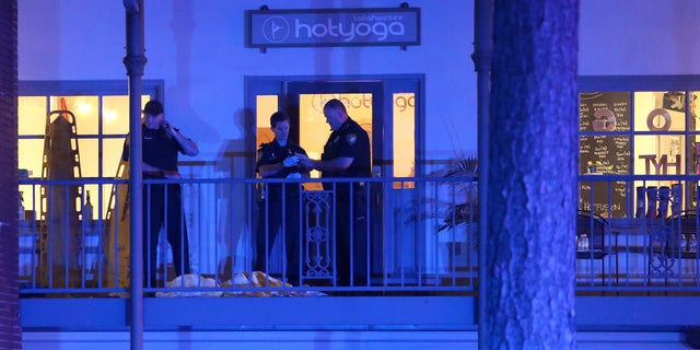 Police investigators work the scene of a shooting, Friday, Nov. 2, 2018, in Tallahassee, Fla. A shooter killed one person and critically wounded four others at a yoga studio in Florida's capital before killing himself Friday, officials said. (AP Photo/Steve Cannon)