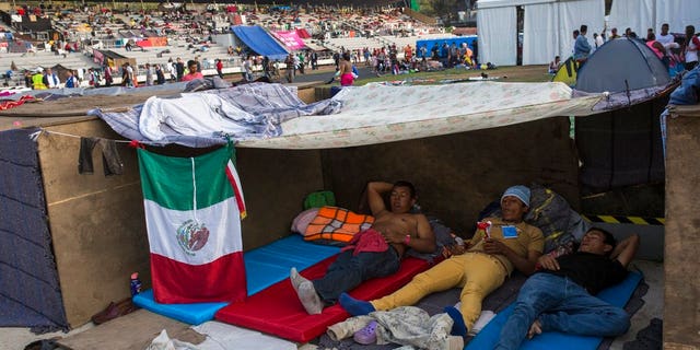 Central American migrants rest at the Jesus Martinez stadium in Mexico City, Tuesday, Nov. 6, 2018. Humanitarian aid converged around the stadium in Mexico City where thousands of Central American migrants winding their way toward the United States were resting Tuesday after an arduous trek that has taken them through three countries in three weeks. (AP Photo/Rodrigo Abd)
