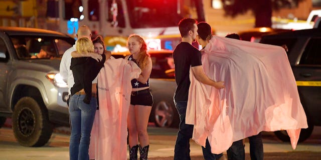 People comfort each other as they stand near the scene of a mass shooting in Thousand Oaks, Calif., early Thursday morning.