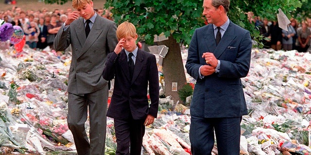 Prince Charles, right, accompanies his sons Prince William, left and Prince Harry after they arrived at Kensington Palace to view tributes left in memory of their mother Princess Diana in London in 1997. 