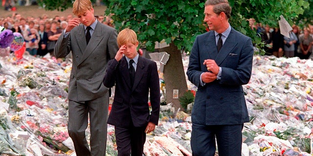 In this Friday, Sept. 5, 1997 file photo, Britain's Prince Charles accompanies his sons Prince William and Prince Harry after they arrived at Kensington Palace to view tributes left in memory of their mother Princess Diana in London. (AP Photo/David Brauchli, File)