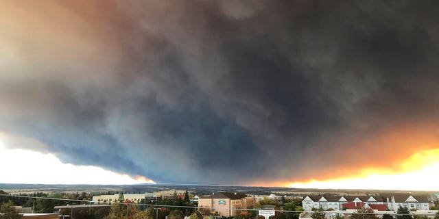 The massive plume from the Camp Fire, burning in the Feather River Canyon near Paradise, Calif., wafts over the Sacramento Valley as seen from Chico, Calif.