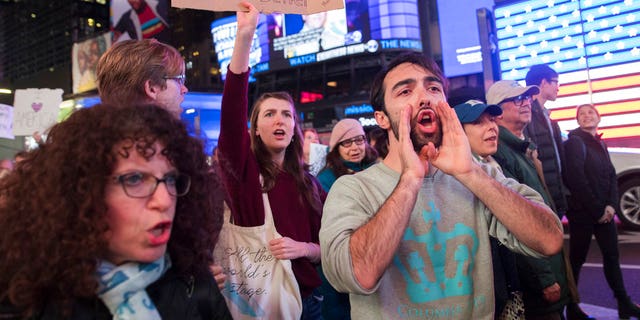 Protesters march through Times Square during a demonstration in support of special counsel Robert Mueller, Thursday, Nov. 8, 2018, in New York. A protest in New York City has drawn several hundred people calling for the protection of Mueller's investigation into potential coordination between Russia and President Donald Trump's campaign. (AP Photo/Mary Altaffer)