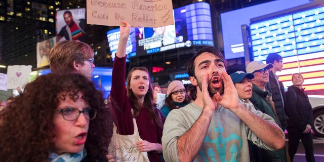 Protesters march through Times Square during a demonstration in support of special counsel Robert Mueller, Thursday, Nov. 8, 2018, in New York. A protest in New York City has drawn several hundred people calling for the protection of Mueller's investigation into potential coordination between Russia and President Donald Trump's campaign. (AP Photo/Mary Altaffer)
