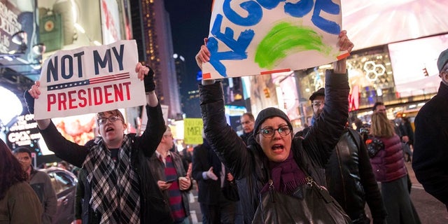 Protesters march through Times Square during a demonstration in support of special counsel Robert Mueller, Thursday, Nov. 8, 2018, in New York. A protest in New York City has drawn several hundred people calling for the protection of Mueller's investigation into potential coordination between Russia and President Donald Trump's campaign. (AP Photo/Mary Altaffer)
