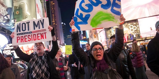 Protesters march through Times Square during a demonstration in support of special counsel Robert Mueller, Thursday, Nov. 8, 2018, in New York. A protest in New York City has drawn several hundred people calling for the protection of Mueller's investigation into potential coordination between Russia and President Donald Trump's campaign. (AP Photo/Mary Altaffer)