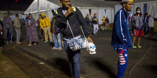 A Central American migrant prepares to leave the temporary shelter in the Jesus Martinez stadium, in Mexico City, Friday, Nov. 9, 2018.