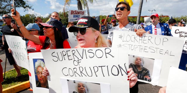 A crowd protests outside the Broward County Supervisor of Elections office Friday, Nov. 9, 2018, in Lauderhill, Fla. A possible recount looms in a tight Florida governor, Senate and agriculture commission race. (AP Photo/Joe Skipper)