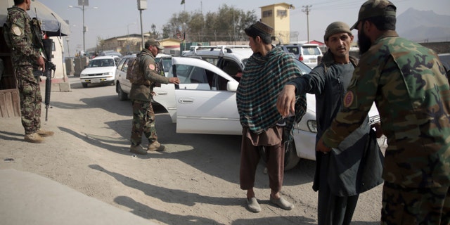 In this Oct. 26, 2018 photo, Afghan National Security Forces search passengers and their vehicles at a checkpoint in Kabul, Afghanistan. (AP Photo/Massoud Hossaini)