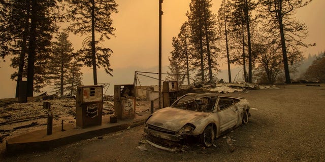 As the Camp Fire burns nearby, a scorched car rests by gas pumps near Pulga, Calif., on Sunday.