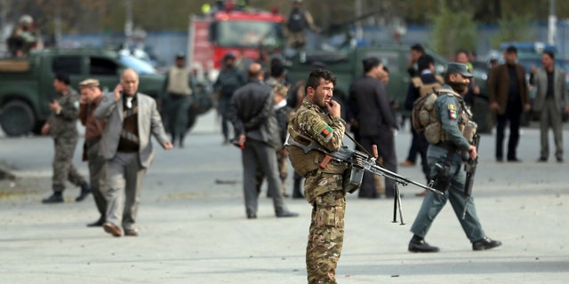 Security forces inspect the site of a deadly blast near a demonstration by hundreds of minority Shiites, in the center of Kabul, Afghanistan, Monday, Nov. 12, 2018. Afghan officials confirmed several people were killed in the explosion near a high school and about 500 meters (yards) from where people gathered to denounce Taliban attacks in Jaghuri and Malistan districts of eastern Ghazni province.