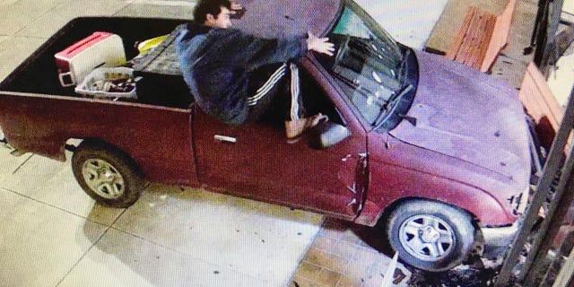 Keith Cavalier is seen climbing out of a Toyota Tacoma truck after it hit the east side of the courthouse in Gulfport, Miss., Saturday morning, Nov. 10, 2018. (Harrison County Board of Supervisors via the AP)