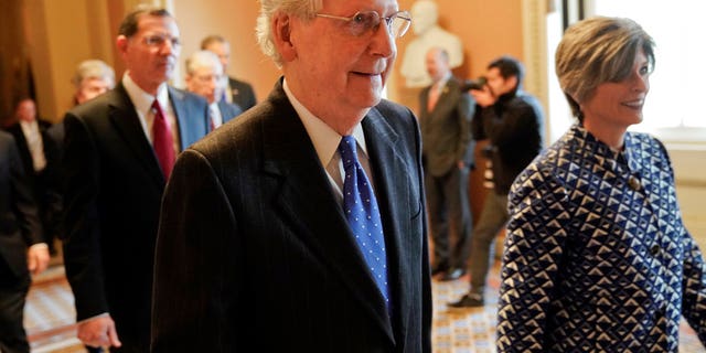 Senate Majority Leader Mitch McConnell, R-Ky., center, walks out to speak to media after a meeting in his office at the Capitol in Washington.