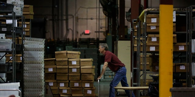 An employee at the Palm Beach County Supervisor of Elections office pushes a pallet of ballot boxes during a recount on Wednesday, Nov. 14, 2018, in West Palm Beach, Fla. (AP Photo/Brynn Anderson)
