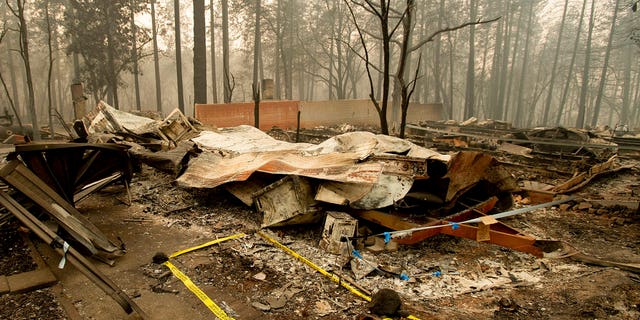 Tape marks a spot where sheriff's deputies recovered the body of a Camp Fire victim on Wednesday, Nov. 14, 2018, in Paradise, California.