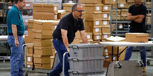 Employees bring out boxes of ballots before resuming a recount at the Palm Beach County Supervisor Of Elections office, Thursday, Nov. 15, 2018, in West Palm Beach, Fla. (AP Photo/Wilfredo Lee)