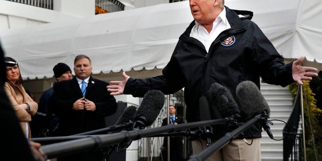 President Donald Trump answers questions from members of the media as he leaves the White House, Saturday Nov. 17, 2018, in Washington, en route to see fire damage in California. At far left is White House press secretary Sarah Huckabee Sanders. (AP Photo/Jacquelyn Martin)