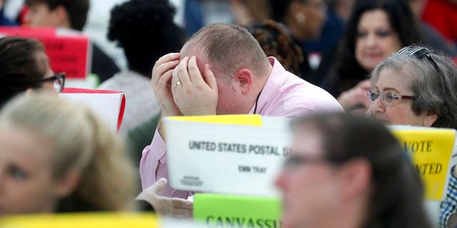 Volunteers look over ballots during the hand count at the Broward County Supervisor of Elections office in Lauderhill, Fla., on Saturday, Nov. 17, 2018.