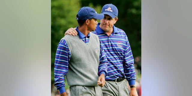 In this Sept. 17, 2004, file photo, U.S. team player Phil Mickelson puts his arm around partner Tiger Woods as they walk off the 18th green after they lost to Europeans Darren Clarke and Lee Westwood on the final hole of their foursomes match at the 35th Ryder Cup at Oakland Hills Country Club in Bloomfield Township, Mich. They play a high-stakes exhibition Friday in Las Vegas in golf's first venture using pay-per-view.