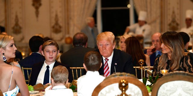 President Donald Trump, center, and first lady Melania Trump, right, sit with their family as they have Thanksgiving Day dinner at their Mar-a-Lago estate in Palm Beach, Fla., Thursday, Nov. 22, 2018. Ivanka Trump, left, and Barron Trump, second from left, attend. (AP Photo/Susan Walsh)