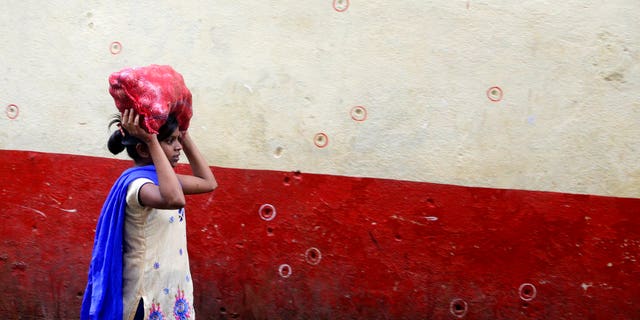 A girl walks past a wall in Chabad House and wears bullet marks on the eve of the tenth anniversary of the Mumbai terrorist attacks in Mumbai, India, on Sunday, November 25, 2018.