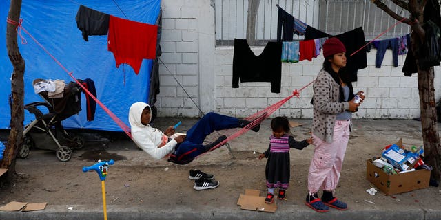 A migrant family camps on the street outside of an overflowing sports complex where more than 5,000 Central Americans are sheltering, in Tijuana, Mexico, Wednesday, Nov. 28, 2018.