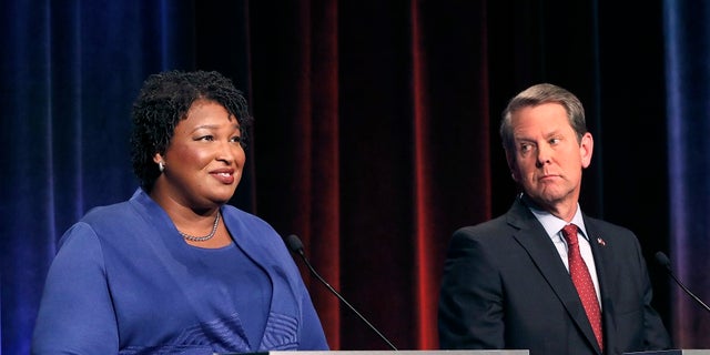 FILE - Democratic gubernatorial candidate for Georgia Stacey Abrams, left, speaks as her Republican opponent Secretary of State Brian Kemp looks on during a debate in Atlanta.