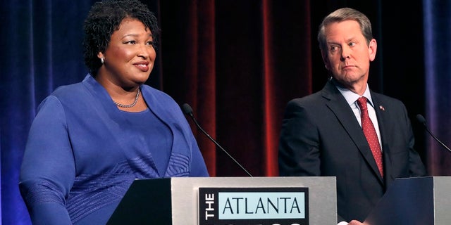 FILE - Democratic gubernatorial candidate for Georgia Stacey Abrams, left, speaks as her Republican opponent Secretary of State Brian Kemp looks on during a debate in Atlanta.