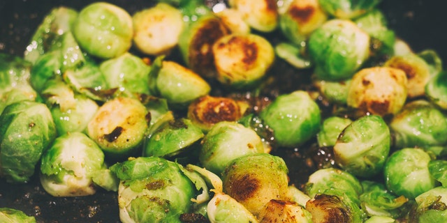 Roasted Brussels sprouts are shown in a pan, close up. This stir-fry recipe as detailed here is very easy to prepare. 