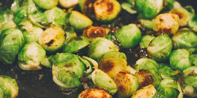 Roasted Brussels sprouts are shown in a pan, close up. This stir-fry recipe as detailed here is very easy to prepare.