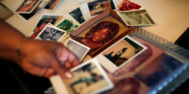 In this Tuesday, March 12, 2013 photo, Brenda Gordon looks at photos of her mother, Carol Alford, at her apartment in Los Angeles. Alford was murdered by Samuel Little in 1987.