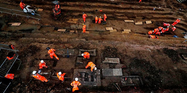 Field archaeologists work on the excavation of a late 18th to mid 19th-century cemetery under St James Gardens near Euston train station in London on November 1, 2018, as part of the HS2 high-speed rail project. - Tucked behind one of London's busiest railway stations, a small army of archaeologists shovel thick clay as they clear a vast burial site to make way for a new train line. (Photo by Adrian DENNIS / AFP)
