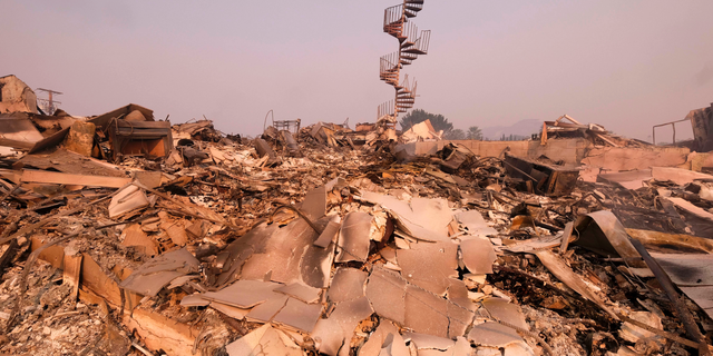 The charred remains of the burned out home are seen in Malibu, Calif., Saturday, Nov. 10, 2018. Officials took advantage of temporarily calm conditions Saturday to assess damage from the blaze that's burned 109 square miles outside downtown Los Angeles. (AP Photo/Ringo H.W. Chiu)