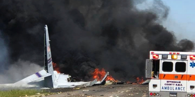 FILE - In this Wednesday, May 2, 2018 file photo, flames and smoke rise from an Air National Guard C-130 cargo plane after it crashed near Savannah, Ga. Investigators say the cause of the military plane crash that left nine people dead was pilot error. Nine airmen from the Puerto Rico National Guard died when the plane plunged onto Georgia Highway 21 shortly after takeoff from the Savannah airport. (James Lavine via AP, File)