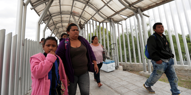 FILE- In this Saturday, Nov. 3, 2018, file photo immigrants seeking asylum in the United States walk off of the the International Bridge in Reynosa, Mexico. Asylum seekers already camping at border crossings worry that how the Trump administration responds to the caravan of some 4,000 Central American migrants and three much smaller ones hundreds of miles behind it could leave them shut out. (AP Photo/Eric Gay, File)