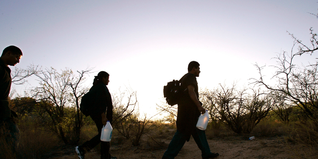FILE - In this Tuesday, April 25, 2006 file photo, a group of migrants cross the desert between Sasabe, Mexico, and Sasabe, Ariz. As people worldwide flee war, hunger and a lack of jobs, global migration has soared to record highs, with more than 258 million international migrants in 2017. That is an increase of 49 percent from the turn of the century, according to the United Nations. (AP Photo/Gregory Bull)