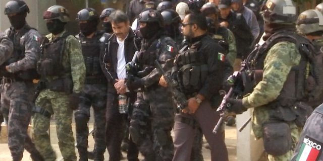 FILE - In this May 2, 2017, file photo, Damaso Lopez, a leader in Mexico's Sinaloa drug cartel, is escorted by police after his capture at an upscale apartment building in Mexico City. Lopez, a top lieutenant to drug kingpin Joaquin "El Chapo" Guzman, was sentenced to life in prison in a Virginia courtroom on Friday, Nov. 30, 2018. (AP Photo/Jorge Barrera, File)