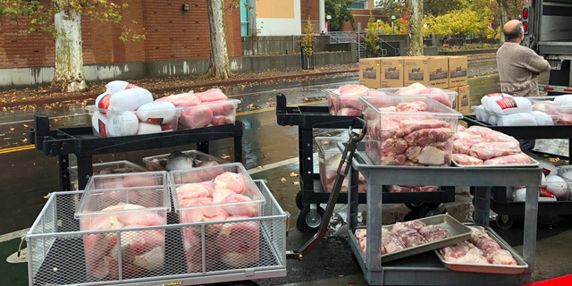 Hundreds of frozen turkeys are unloaded on the campus of California State University, in Chico, Calif., Wednesday, Nov. 21, 2018. The nonprofit World Central Kitchen is preparing them for a Thanksgiving meal for residents displaced by the Camp Fire in Northern California. The fire ignited Nov. 8 and devastated Paradise, Calif., and surrounding communities.